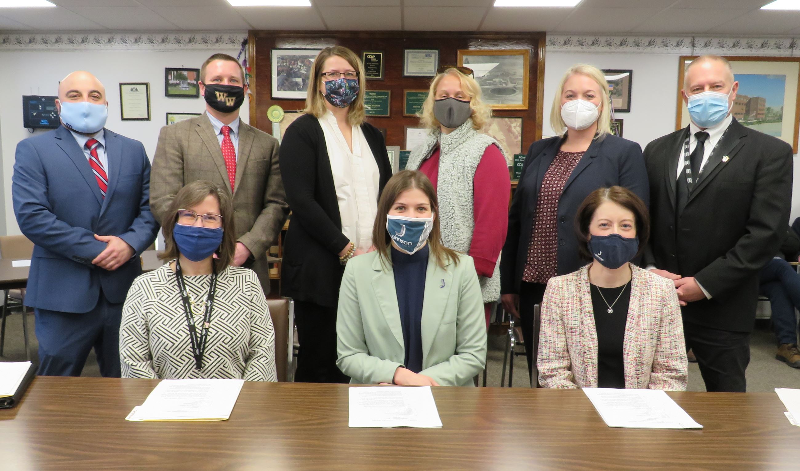 Johnson College representative pose with the Commissioners and officials from the schools & libraryr