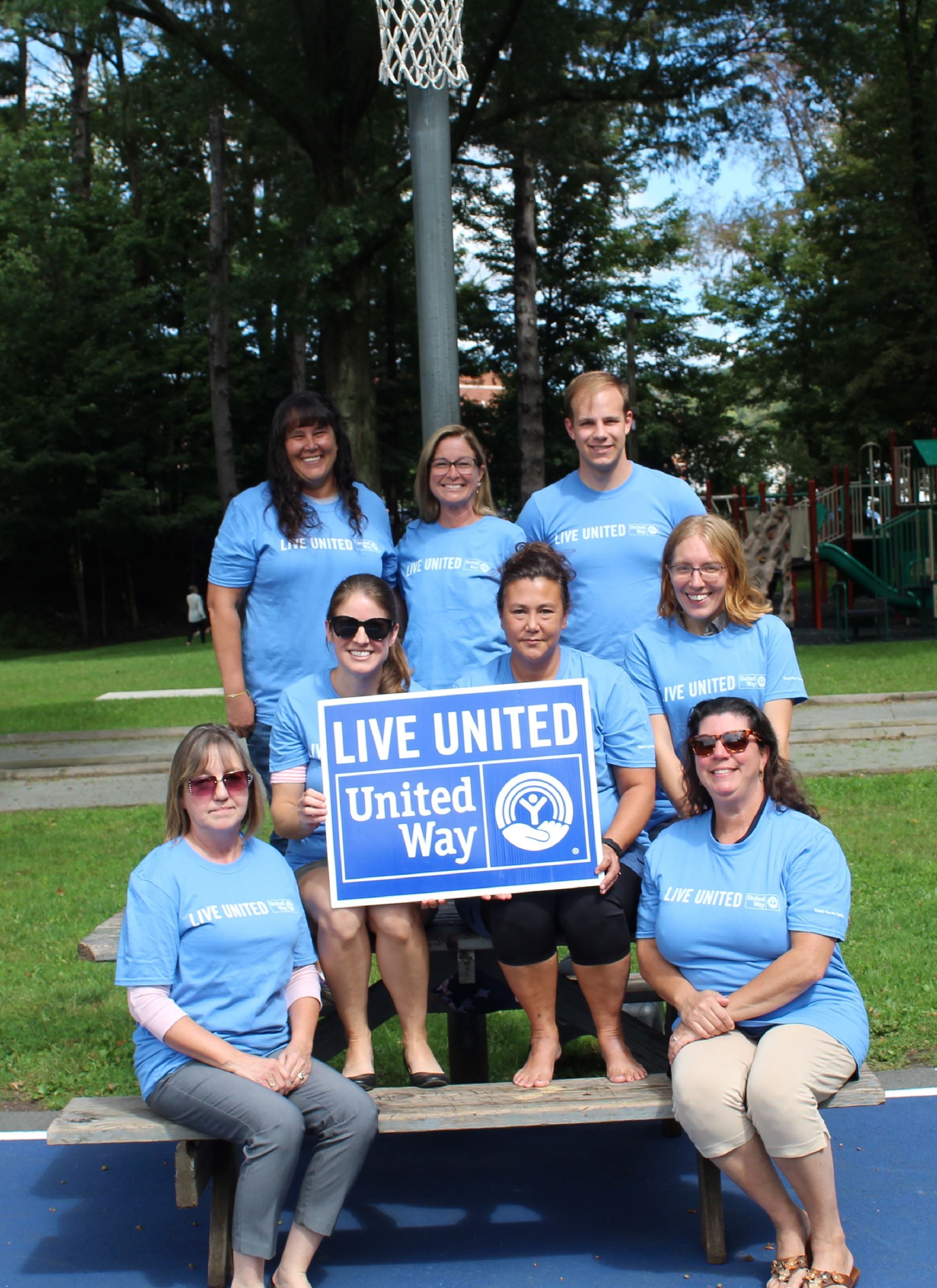 System of Care volunteers pose with United Way officials at the refurbished basketball courts.